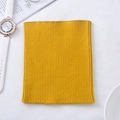 Soft yellow cashmere knit neck warmer scarf with elastic ribbed texture in flat lay - Turmeric