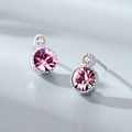 Macro detail of silver stud earrings featuring pink circular stones and tiny crystals - Stud Earrings / Pink