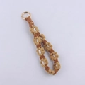 Detail of handmade woven daisy keychain with earthy tone cotton flowers and gold spring buckle - Light Coffee