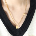 Double layered gold stainless steel necklace with heart and square charms on a model - 50+5cm / Gold