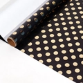 Premium black gift wrapping paper featuring metallic gold foil polka dots in roll form - Dot