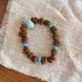 Handmade beaded bracelet with brown bean beads, turquoise stones, and a blue fish pendant - Blue/Ceramic Fish