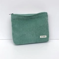 Detail of green corduroy makeup bag featuring soft ribbed texture and a branded fabric label - Grass Green