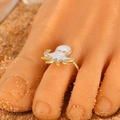 Adjustable golden octopus toe ring with white enamel detail on beach sand background - White Octopus (7584)
