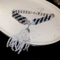 Dettaglio della collana in zircone con nappe di perle su un piatto di ceramica - Nero
