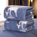Thick blue flannel blanket with white deer and snowflake patterns folded on a bed - Lucky Deer / 70x100cm