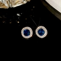 Elegant gold-tone stud earrings featuring round blue crystals with a diamond halo design - Silver Earring Post - Gold - Blue