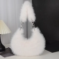 White faux fur crossbody bag with silver chain strap shown in a minimalist studio setting - White