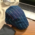 Detailed view of dark blue denim beret with rainbow stitching on a modern desk - Dark Blue Rainbow Stripe