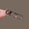 Elegant oval hair claw clip with black crystals and silver metal finish held by hand - Gun Black Rhinestone Style