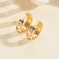 Detail of gold geometric hoop earrings with colorful zircon stones and star engravings - Multicolor Zirconia C-Shape