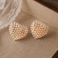Dettaglio di orecchini a cuore in perle con base dorata su pizzo in stile vintage - Cuore di Perla d'Oro