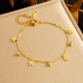 Close-up of gold-plated bracelet with snowflake charms and zircon beads on a display case - Snowflake Style (B1474)