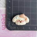 Close-up of a 3cm white dog resin charm with a beige beret measured on a black ruler - Beige Hat Puppy