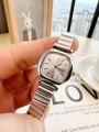 Close-up of a silver square watch dial with stainless steel strap held in hand - Silver White Face