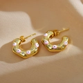 Macro view of C-shape gold earrings with pink enamel evil eye and sparkling crystals - Pink Evil Eye / Gold