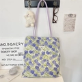 Detailed view of canvas tote with purple floral print and slim shoulder straps - Purple Iris Shoulder Style