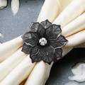 Rond de serviette fleur noire avec cristal central sur une serviette en tissu beige - Noir