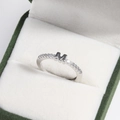 Macro detail of silver ring with letter M design and pavé stones in a premium jewelry box - Platinum M