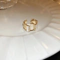 Detail view of the gold oval zircon ring featuring white inlay and layered metal texture - Gold