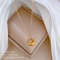 Macro view of golden stainless steel round pendant necklace on a jewelry display box - Gold