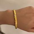 Elegant gold-tone flat bangle featuring a pavé-set triangle zircon embellishment - Triangle Diamond Style (A1172) / Gold