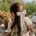 Elegant white lace bow hair clip worn by a model in a romantic garden setting - White