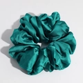 Detail view of emerald green satin scrunchie showing glossy silk texture on white surface - Dark Green Large
