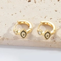 Detail view of gold hoop earring with white evil eye enamel and cubic zirconia stone - Black