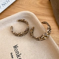 Dettaglio di orecchini a cerchio a C in acetato con motivo tartarugato marrone e perni in argento - Stile a C / Caffè (Stampa leopardata)