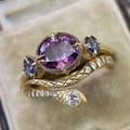 Vintage gold ring set featuring purple zircon stone and detailed snake band on beige velvet - US 6 / Gold