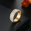 Detailweergave van de drievoudige rij micro-ingelegde zirkoon op een gouden titanium stalen ring. - US 5 / Goud