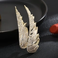 Elegante broche de ala bañado en oro con detalles de pavé de circonitas - Dorado