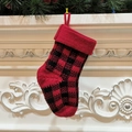Calza di Natale in maglia a quadri rossi e neri appesa su un caminetto decorato - Quadri Neri e Rossi