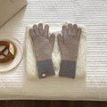 Detalle de guantes de punto a rayas caqui y gris sobre un jersey de invierno blanco - Caqui