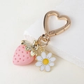 Detail of pink strawberry and white daisy charms on a golden heart-shaped keyring - Sweet Pink Strawberry