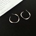 Irregular twisted C-shape silver hoop earrings with metallic finish on black background - 3cm / Silver