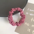 Elastic fabric scrunchie with a classic red and white plaid pattern on a black tray - Red Grid