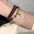 Detail of double-layer garnet bead bracelet with golden tag and jade pendant - Purple/Garnet Color