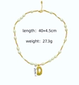 Detailweergave van natuurlijke parelketting met gouden letter D hanger en afmetingen - Letter A / Melkwit