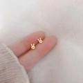 Minimalist 925 silver rabbit stud earrings in gold finish held between fingers - Little Rabbit / Gold