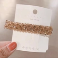 Macro detail of hand-woven champagne crystal hair clip with polished metal base - Champagne