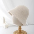 Detalle de sombrero bucket de lana crema con textura de punto en soporte de madera - Ajustable / Beige