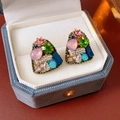 Gros plan de boucles d'oreilles vintage avec strass colorés dans un écrin à bijoux bleu - Tige d'oreille en argent - Doré - Coloré
