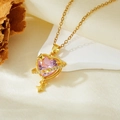 Detailed shot of a pink heart planet pendant with gold finish on a white stone surface - Gold Pink Zircon Heart Planet Necklace (T021)