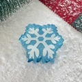 Close-up of blue snowflake hair claw clip with glitter details on festive winter background - Snowflake