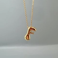Detail of a minimalist gold 3D letter F initial pendant with a polished O-link chain - Letter F Single Pendant