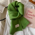 Grass green knitted scarf with emo logo label over clothes in a cozy setting - Fruit Green