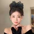 Elegant large black tulle bow hair claw clip for women styled in a hair arrangement - Mesh Bow Claw Clip / Black