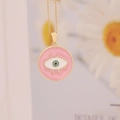 Detail of pink enamel evil eye pendant on a gold 18K chain next to a daisy flower - Pink (2#)